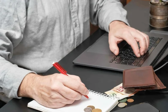 Businessman Accountant Holding Pen Working Desk Using Laptop Calculate Financial Report 3 2048x1365 2